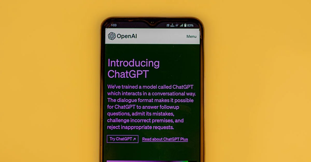 Un téléphone mobile affichant l'écran d'introduction de ChatGPT avec le logo d'OpenAI sur un fond jaune.