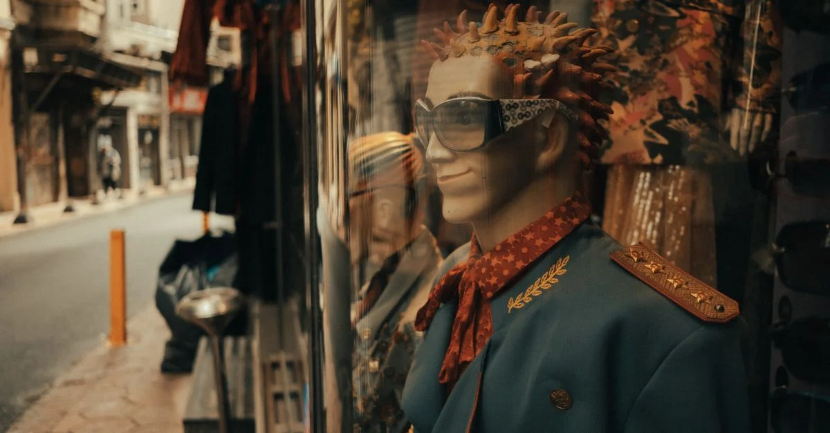 Un mannequin élégant habillé à la mode rétro exposé dans une vitrine de magasin en ville.