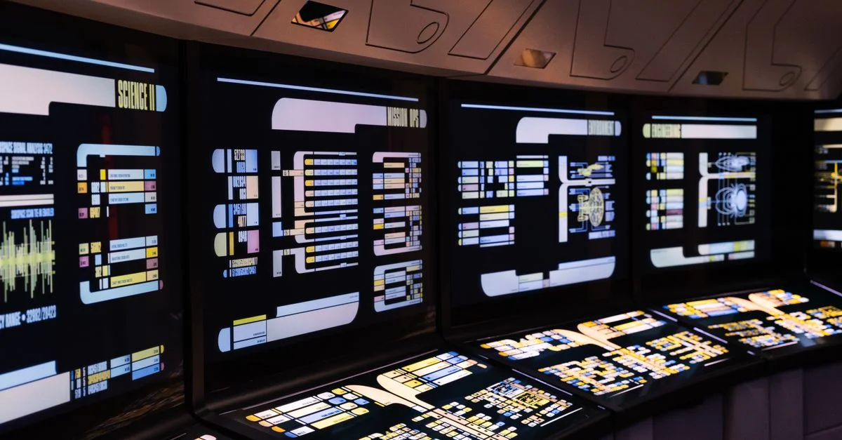 Un centre de commandement high-tech avec des écrans numériques éclairés dans un décor futuriste.