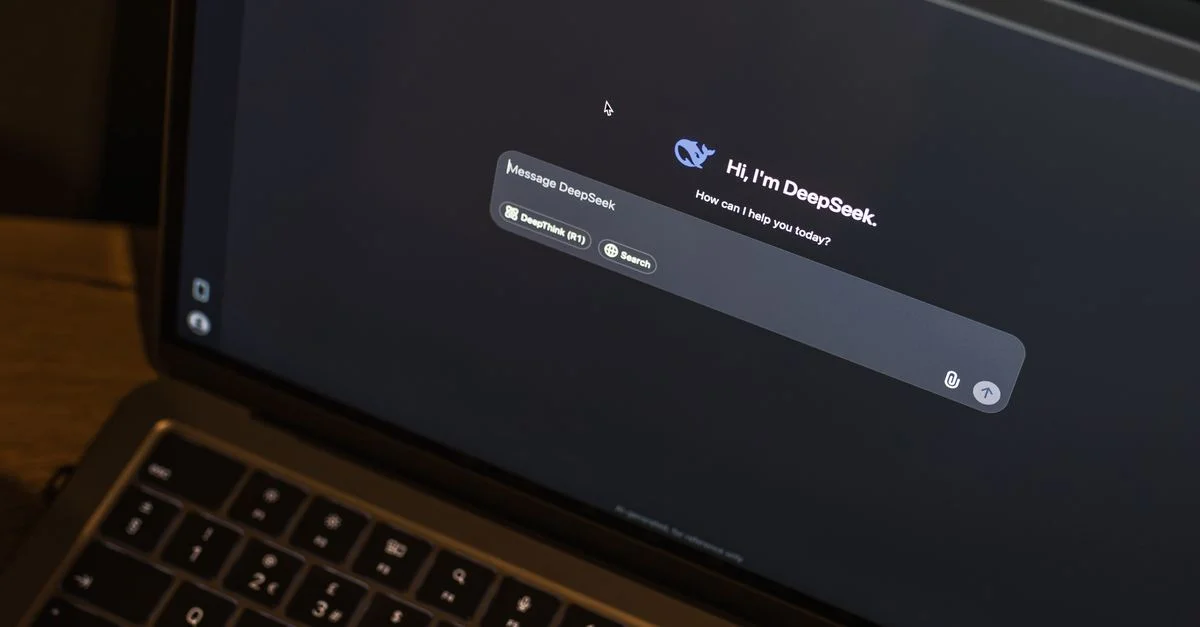 Un ordinateur portable posé sur une table en bois montre une interface de chat IA, mettant en vedette le chatbot DeepSeek en action.