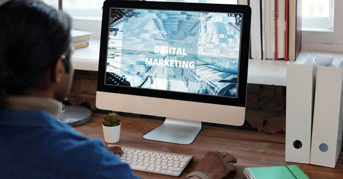 Une personne travaillant sur le marketing numérique dans un espace de travail bien organisé avec un ordinateur.