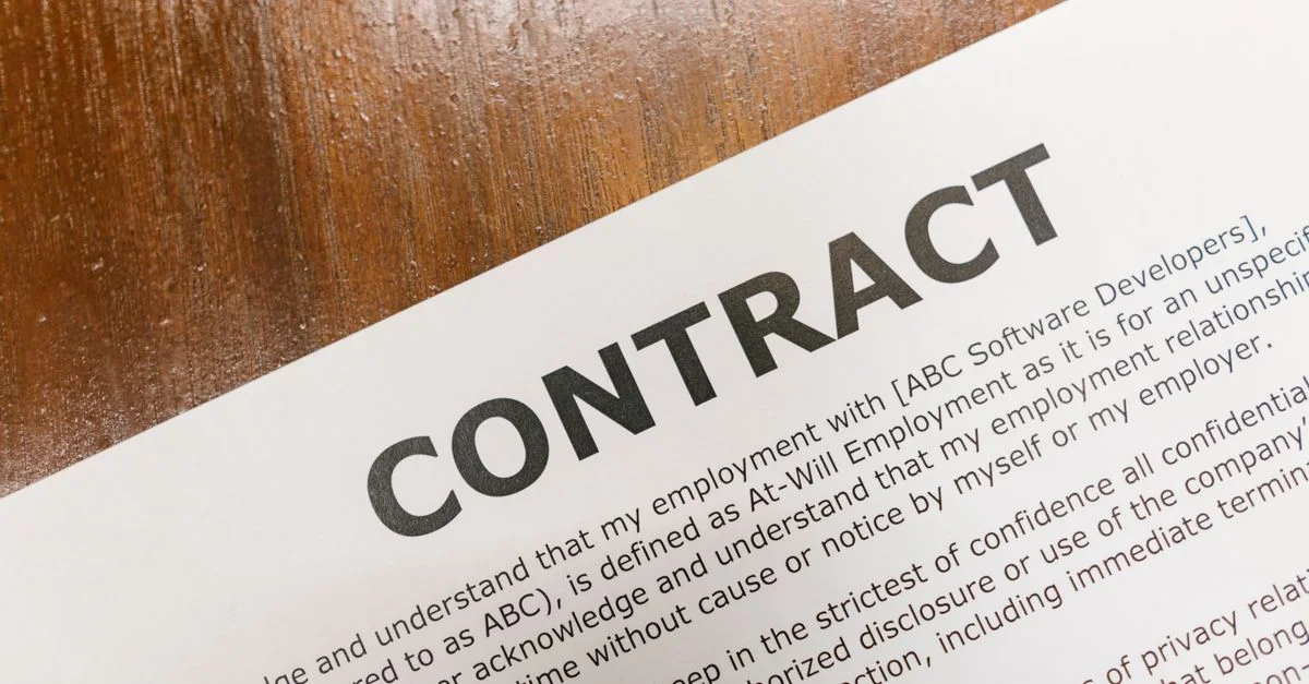 Un gros plan détaillé d'un document de contrat imprimé sur une surface de table en bois.