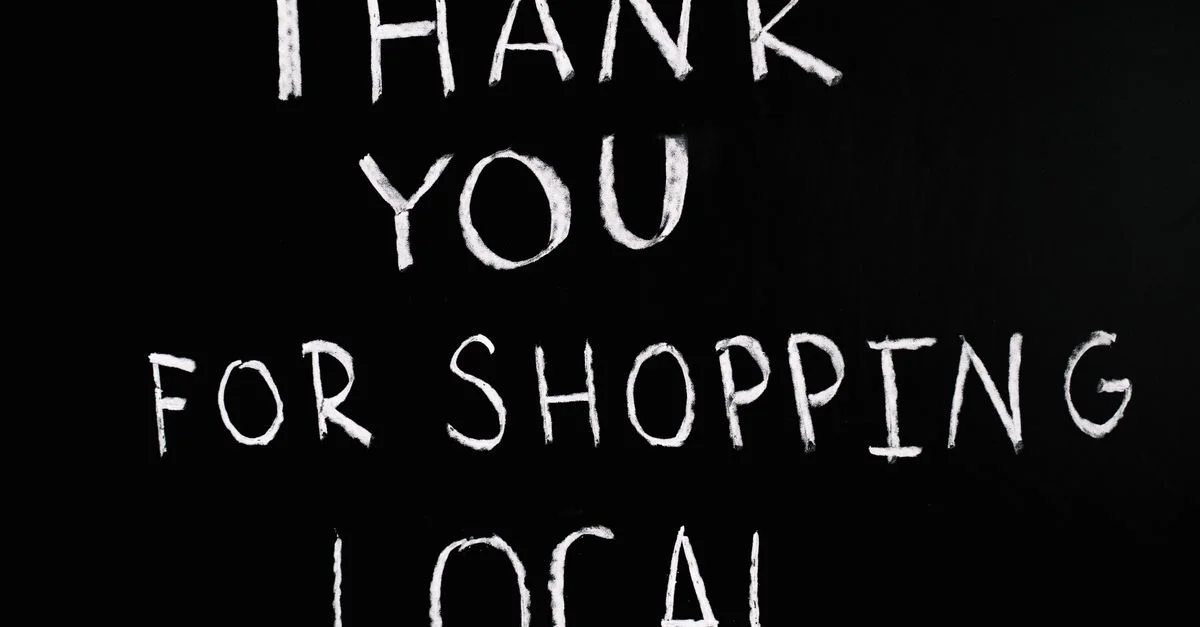 Un tableau noir avec un message manuscrit remerciant de soutenir les entreprises locales.