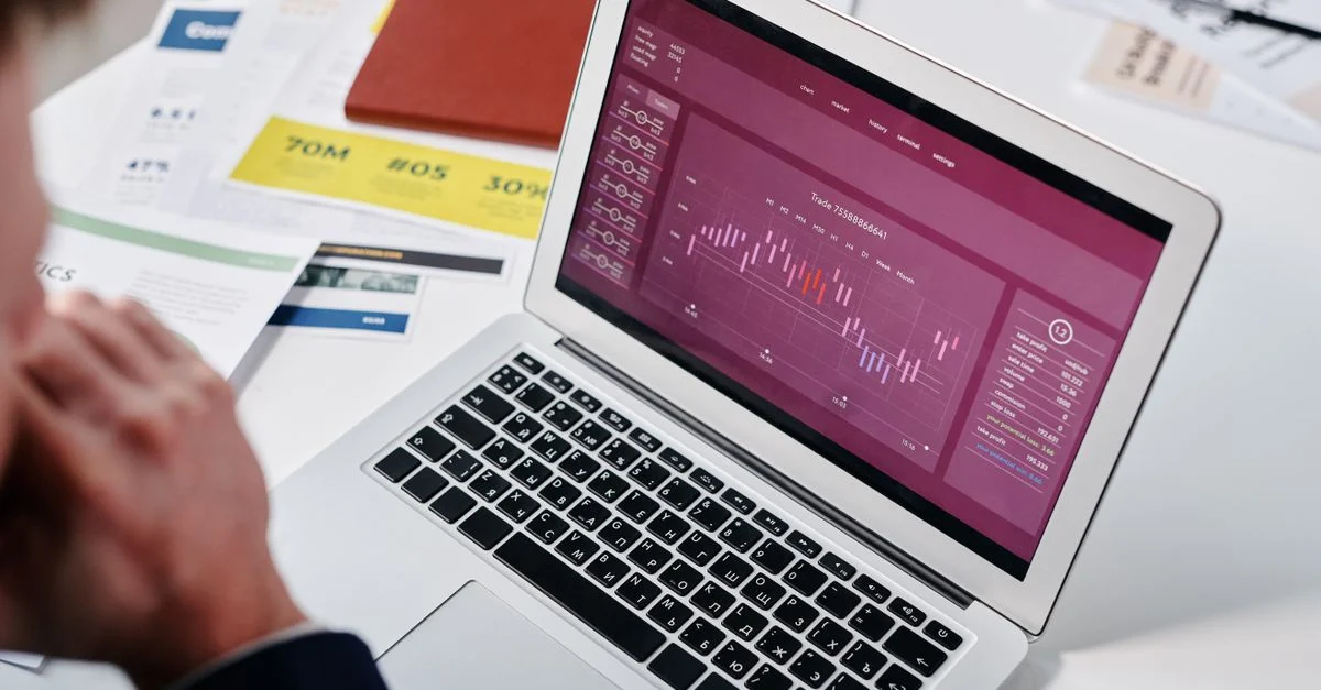 Un professionnel examinant des analyses de données sur un écran d'ordinateur portable dans un cadre de bureau.
