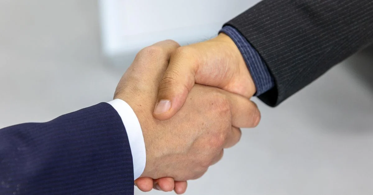 Gros plan de deux hommes d'affaires se serrant la main, symbolisant l'accord et le partenariat.